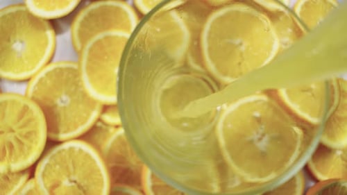 Orange Juice Poured Into Glass with Orange Slices