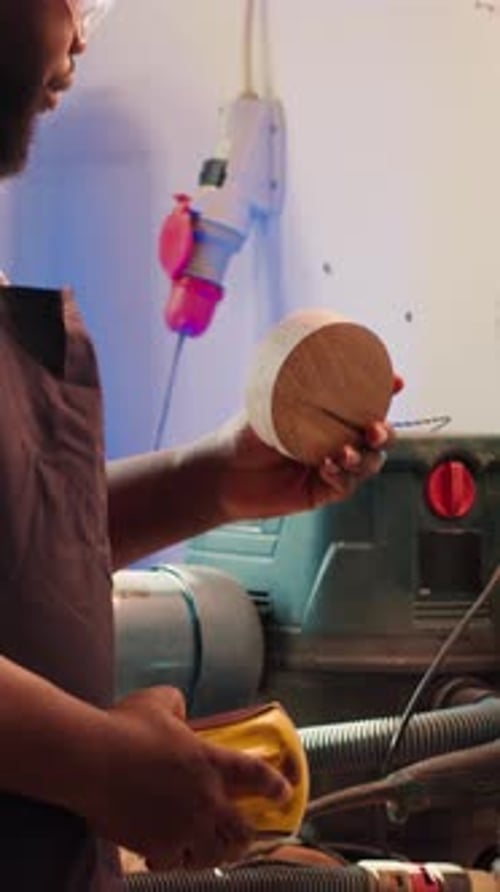 Vertical Video Man in Studio Using Sandpaper for Sanding Wooden Surface