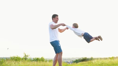 Vater spielt und spinnt mit seinem Sohn im Park in Zeitlupe