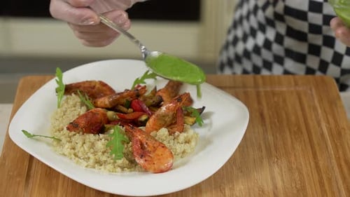 Plating healthy shrimp meal with green sauce