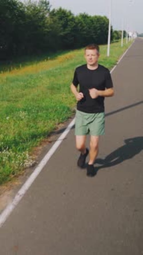 Young Caucasian Man Running Along the Embankment in the Morning Daylight A Jogging Track Along the