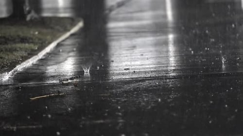 Gotas de lluvia nocturnas en escena urbana en cámara lenta