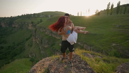 Loving Couple Spinning with Happiness on Top Mountain on Beautiful Sunset