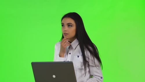 Inspirierende junge Geschäftsfrau beim Brainstorming von Ideen, während sie an ihrem Laptop arbeitet