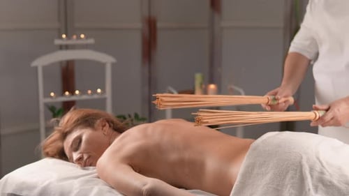 Woman Receiving Relaxing Bamboo Massage at Spa
