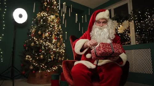Santa Claus Opens Gift in Cozy Christmas Setting