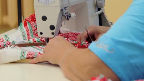 Female textile worker hands sewing cross stitch fabric on weaving machine