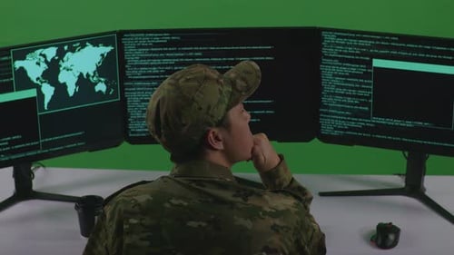 Back View Of Man Soldier Thinking While Write Code With Multiple Computer Screens In Green Screen