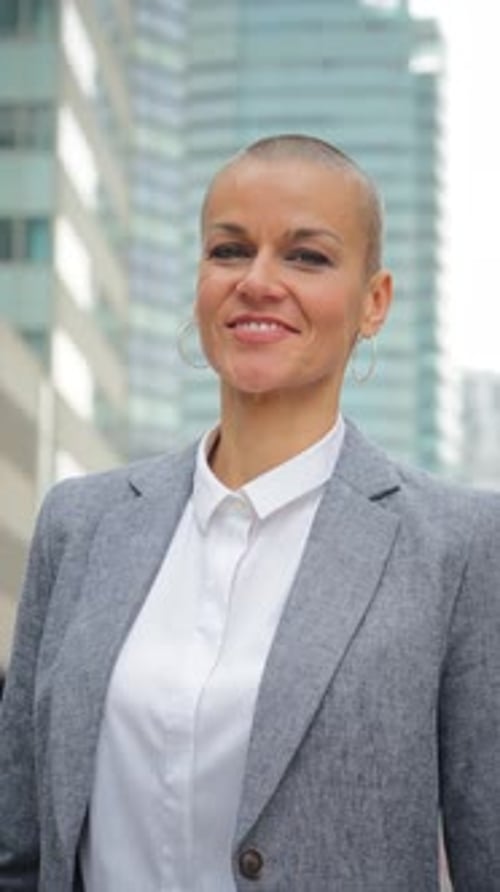 Smiling Woman Stands in Urban Cityscape