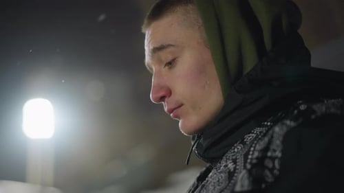 Young Man Warming Hands in Cold Night Air