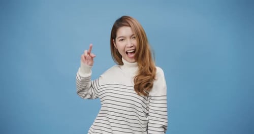 Woman Gesturing and Smiling Against a Blue Background