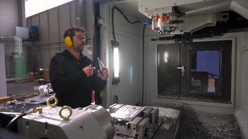Manual Worker Placing a Lathe in the Milling Machine