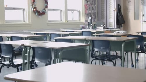 Establishing shot of empty classroom in school with desks