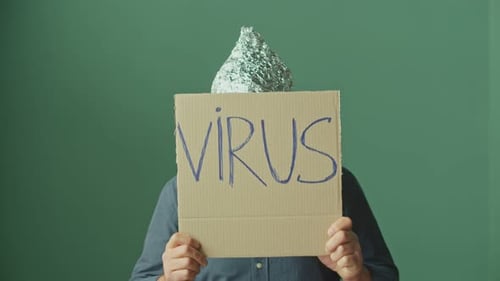 Man Wearing Foil Hat Holding Virus Sign
