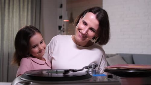 Smiling Woman and Girl Near Vintage Record Player
