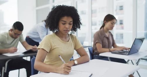 Students, writing and notes in lecture at university for learning, education