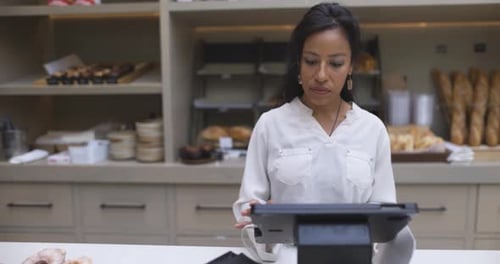 Female Bakery Owner Working at Point of Sale Behind Counter 3034 Years