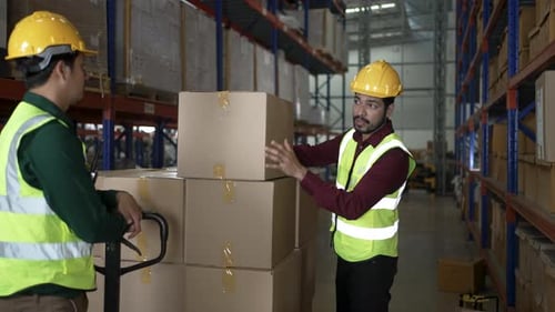 Blue collar workers are working at warehouse.