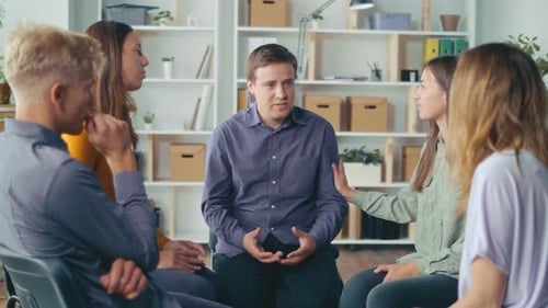 A Group Of People Sitting in a Circle During a Group Therapy Session
