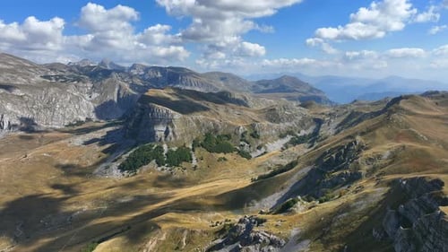 Flight over beautiful mountain peaks covered with grass. Mountain from above on a sunny autumn day.