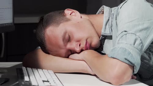 Man Sleeping on Desk at Computer Workplace