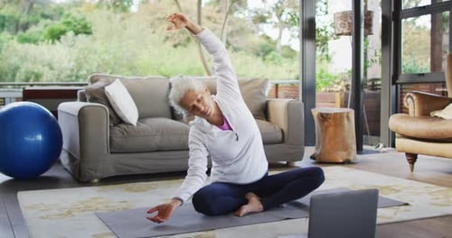 Senior Adult Stretching on Yoga Mat at Home