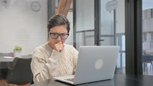 Hustende Inderin tippt auf Laptop