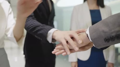 Diverse Team Collaboration: Hands Stacking in Modern Office