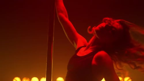 Garota atraente dançando câmera com aparência sexual em Strip Club Bright Spotlights. Em forma