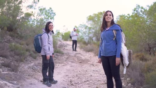 Hikers walk up mountain trail amidst nature. Group of friends hiking mountain hill.