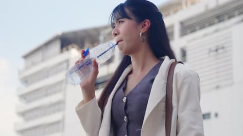 Young Business Businesswoman Holds Water Bottle Talking Outdoors Near Modern Office Buildings Urban