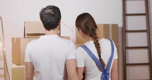 Affectionate Couple Hugging in New Home with Boxes