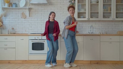 Woman and Child Dancing Together in Kitchen
