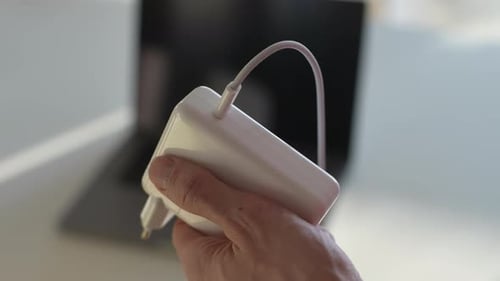 Closeup Cropped Shot of Unrecognizable Male Removing Typec Cable of Laptop Adapter in Sunny Office