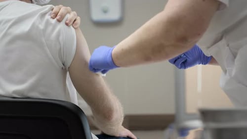 Adult Receives Vaccine Injection in Arm at Hospital