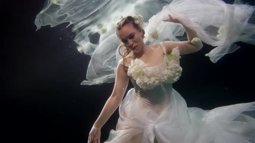 Woman in Dress Dancing Gracefully Underwater
