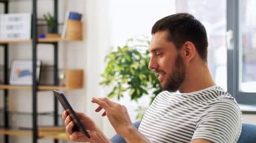 Man Using Tablet at Home During Daytime