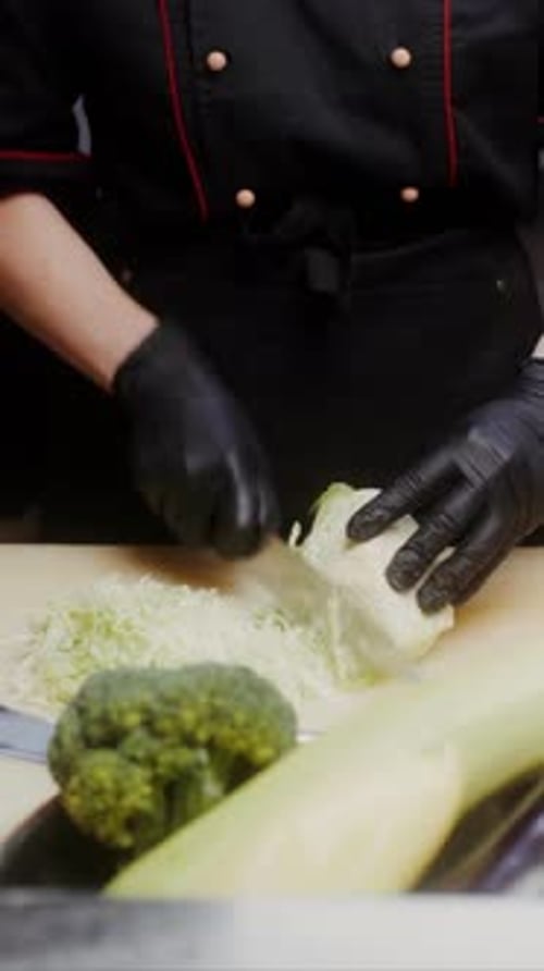 Young Adult Chef Chopping Fresh Vegetables in Kitchen