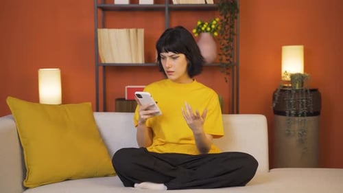 Young Woman Using Phone at Home on Couch
