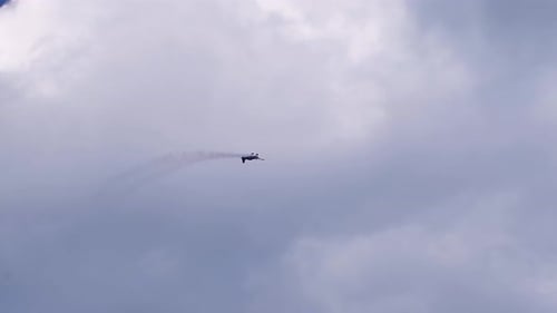 Aerobatic Plane Flying in a Blue Cloudy Sky