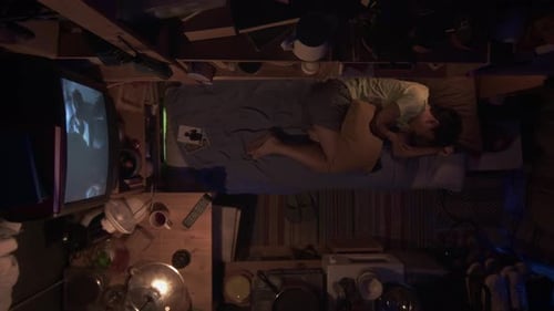 Top View of Asian Micro Flat Dweller Sleeping with Movie on TV
