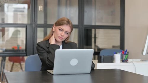 Young Businesswoman having Neck Fatigue and Pain in Office