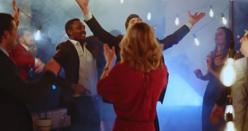 Jovens multirraciais, bonitos e felizes, homens e mulheres dançando, passando por uma festa de convívio, feriado corporativo