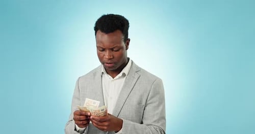 Homem negro, dinheiro e contando finanças, poupança ou salário com sorriso contra um estúdio azul