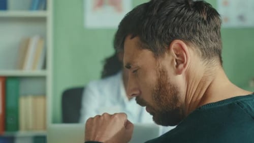Man Coughs in Doctor's Office During Consultation