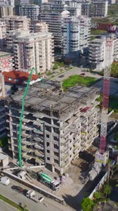 Vídeo vertical de una construcción residencial con ingenieros supervisando a los trabajadores y una grúa en movimiento