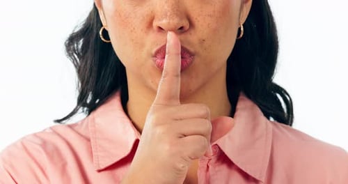 Secret, face and mouth of woman with finger on lips in studio for sign of privacy