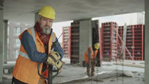 Porträt eines Bauarbeiters mit Handgabelhubwagen am Arbeitsplatz