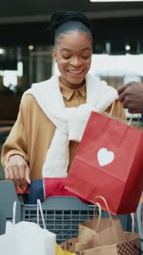 Une femme souriante achète joyeusement de nouveaux vêtements dans un environnement de vente au détail lumineux et moderne
