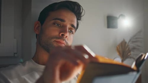 Man Relaxing Indoors Reading a Book Close-up
